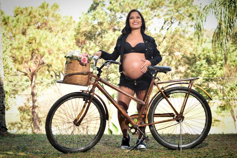 Noiva posando com a bike em um ensaio de gestante em Sabará